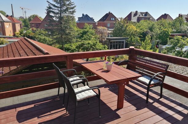 - große Dachterrasse mit Sitzmöbel, Sonnenschirm und Tisch